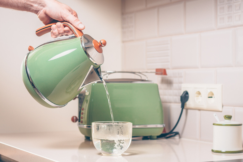 Pouring water into a cup of kettle in a retro style
