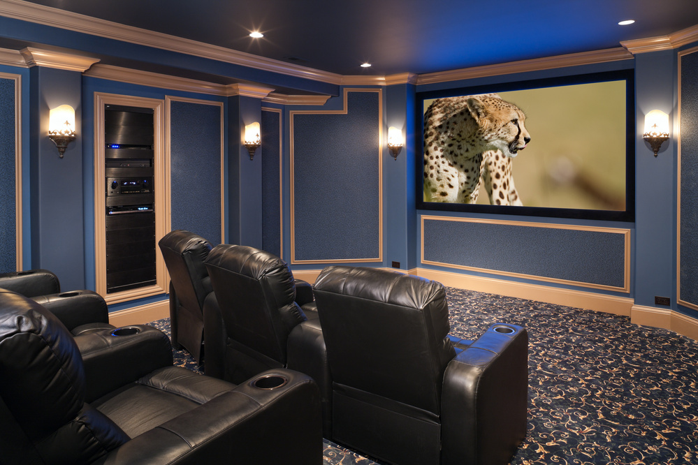 Black leather chairs adorn a beautiful home theatre.